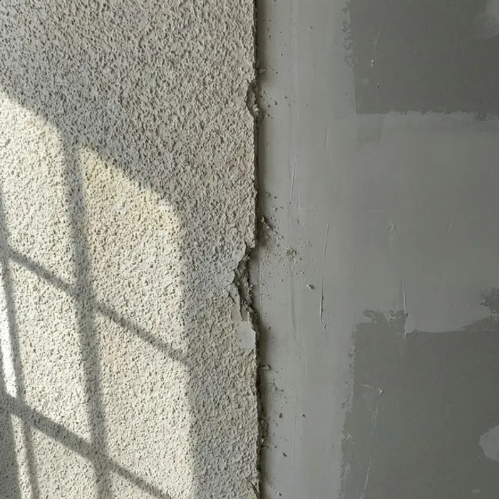 Sharp detail line showing old popcorn texture and newly scraped ceiling