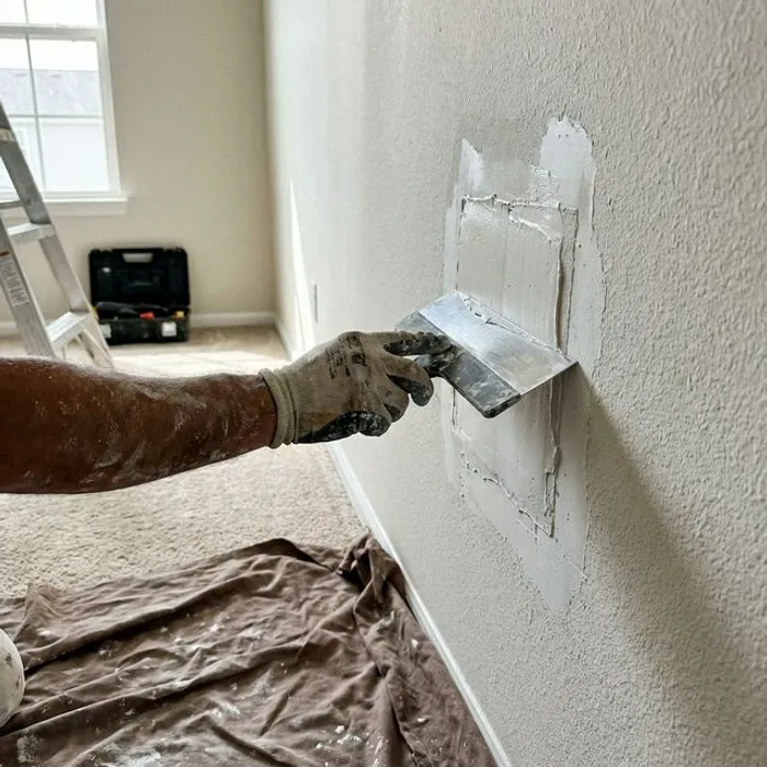 Drywall contractor patching a hole in Bakersfield